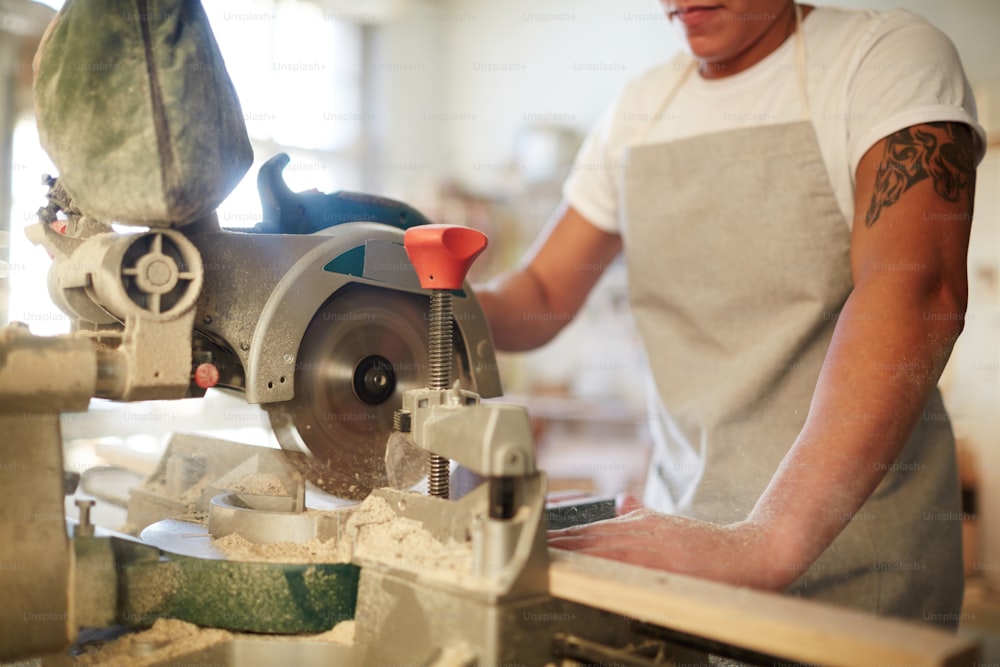 電動工具または機械で木の板を鋸で切る大工仕事のスペシャリスト