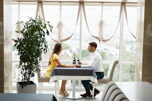 Beautiful Couple In Love On Romantic Date In Restaurant. Happy Smiling Couple Enjoying Romantic Dinner, Drinking Wine And Celebrating Holiday, Special Occasion. High Quality Image.