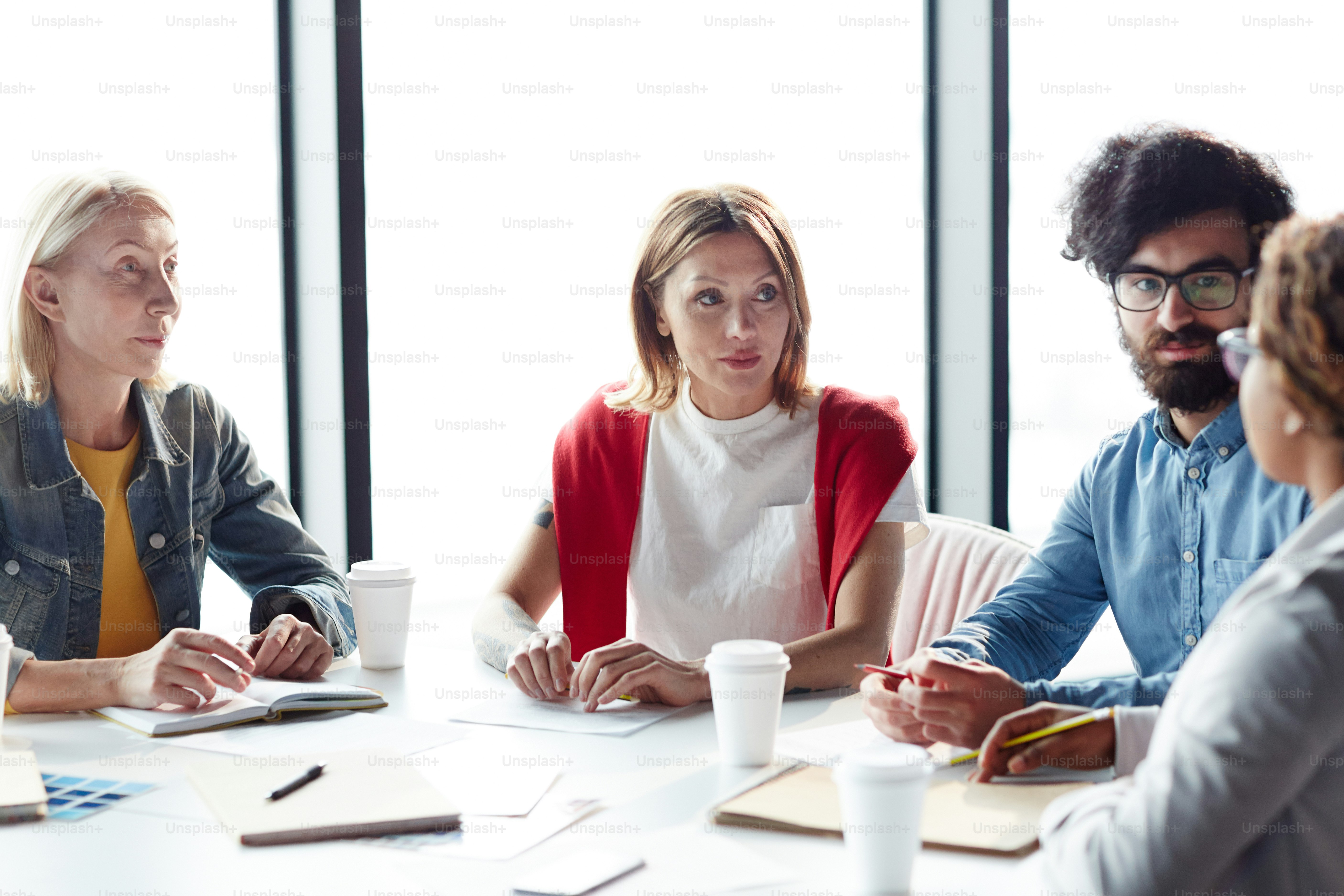 Serious concentrated multiethnic business colleagues attentively ...