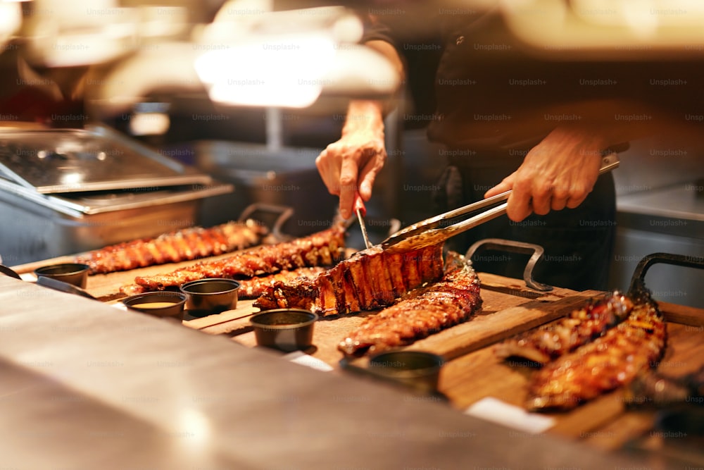 Essen im Restaurant. Barbecue Schweinerippchen in Grillbar. Spareribs auf Holztablett in der Restaurantküche. Hohe Auflösung