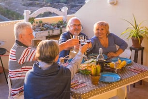 아름다운 노인 그룹은 재미 있고 테라스에서 야외에서 저녁 식사를 즐기며 미소와 재미로 함께 식사를합니다. 휴가 또는 일상 생활에서 여가 활동을 은퇴했습니다. 친구들과 밤과 시간