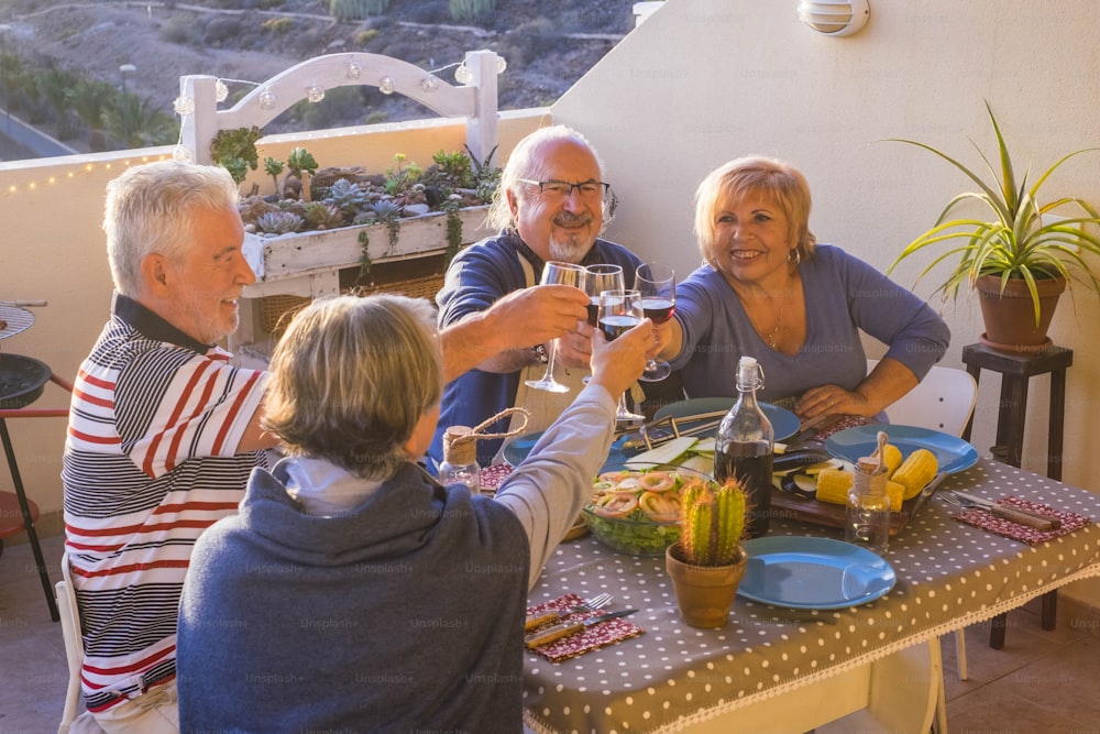 grupo de lindos adultos idosos se divertem e desfrutar de um jantar ao ar livre no terraço comendo junto com sorrisos e diversão. atividade de lazer aposentada em férias ou vida diária. noite e tempo com os amigos