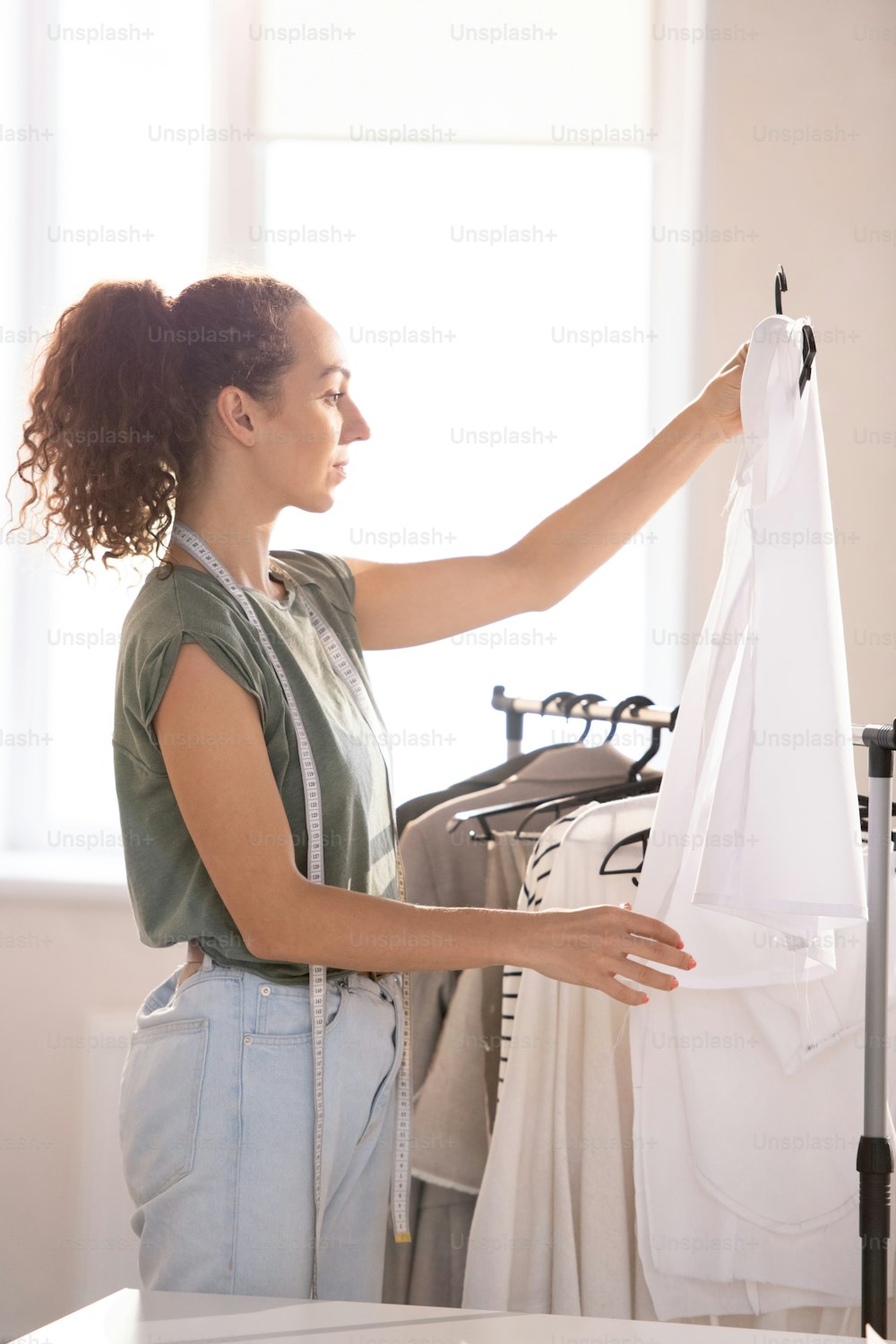 Foto Joven sastre en ropa casual mirando la blusa en sus manos después de terminar con artículos para la venta – Industria Imagen en Unsplash