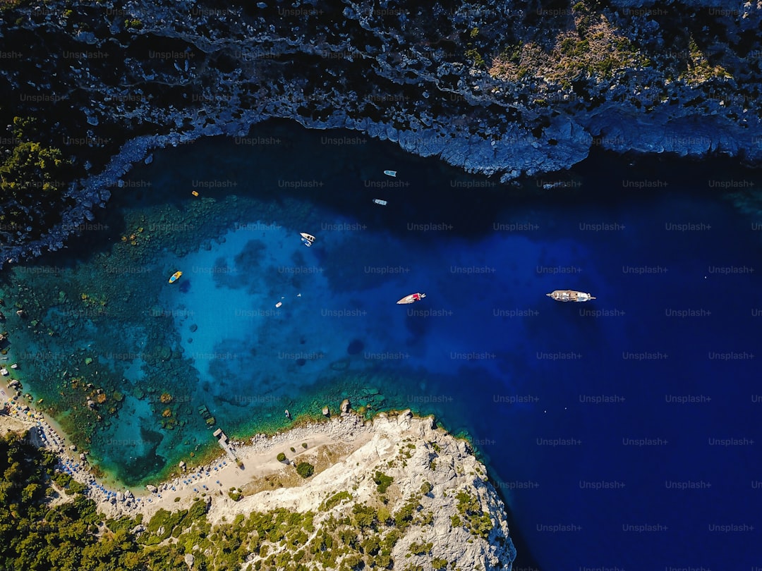 Aerial shot of beautiful blue lagoon at hot summer day with sailing boat. Top view.