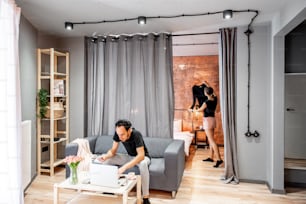 Modern living room interior with motion blurred couple doing their housework