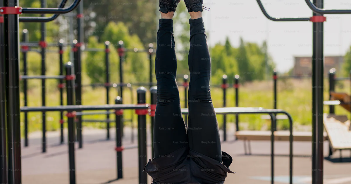 Handstand Front View Front view of young shirtless muscular athlete doing handstand while ...