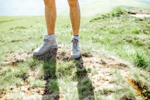 Close-up of a male legs in trekking shoes outdoors