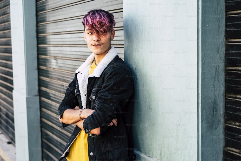 Portrait of handsome and young teenager boy man with violet diversity alternative hair look style - concept of modern people student age