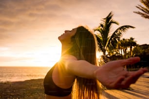 Gesunde Menschen Lebensstil genießen Sonnenuntergang und Fitnessaktivität allein - schöne Frau spürt die Sonne und den Ozean Sauerstoff nach dem Training Sportunterricht - offene Arme und Freiheit atmen