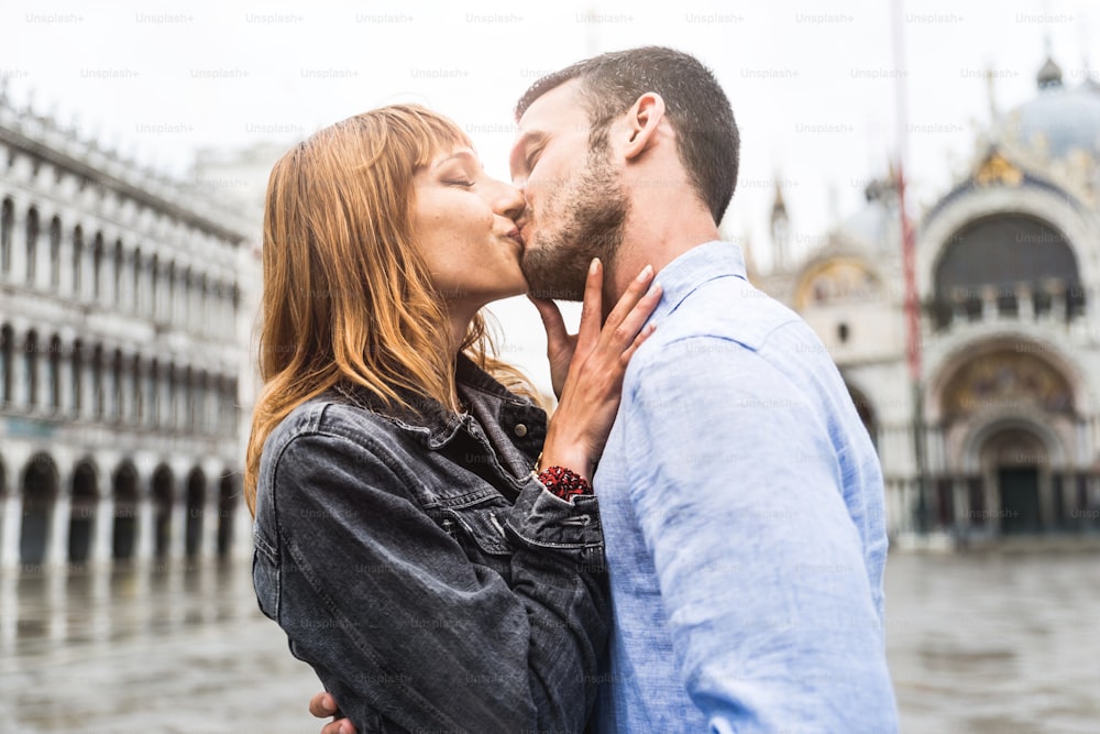 Hermosa pareja de enamorados en Venecia, Italia. Amantes románticos besándose en una cita en la Plaza de San Marcos, Venecia.