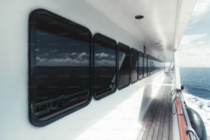 豪華な白いサファリヨットのサイドデッキの広角ビューと、デッキハウスの木製の床の窓の列と青い海の水で船尾の水景