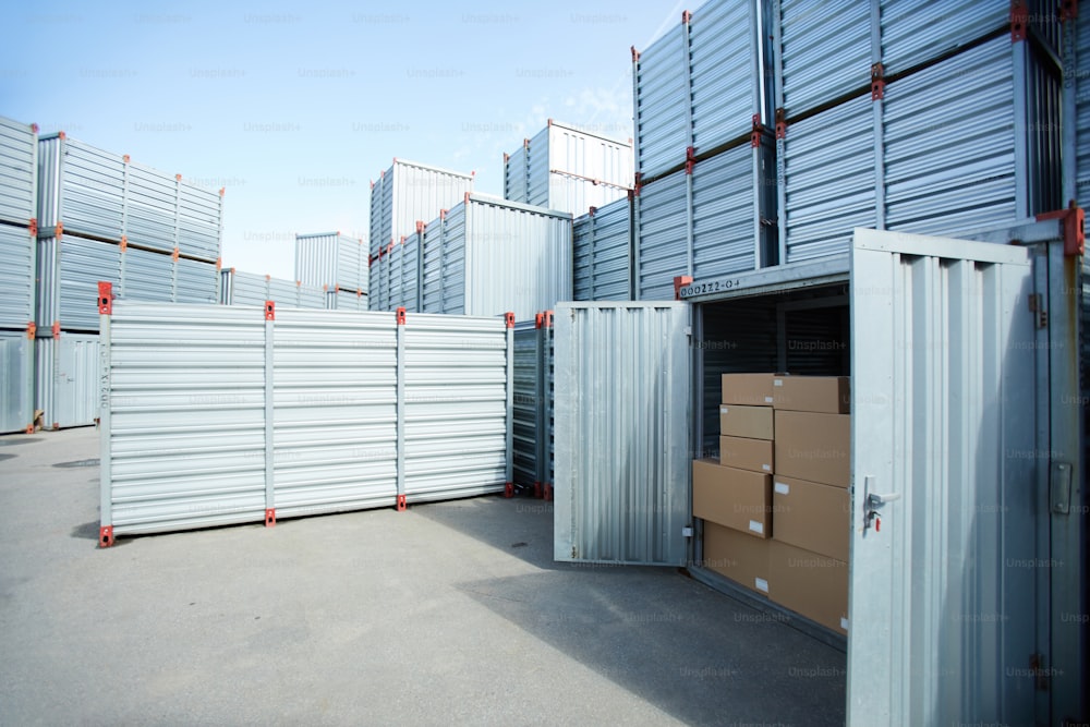 Área de almacenamiento de carga moderna con contenedor de metal, contenedor espacioso abierto con pila de cajas