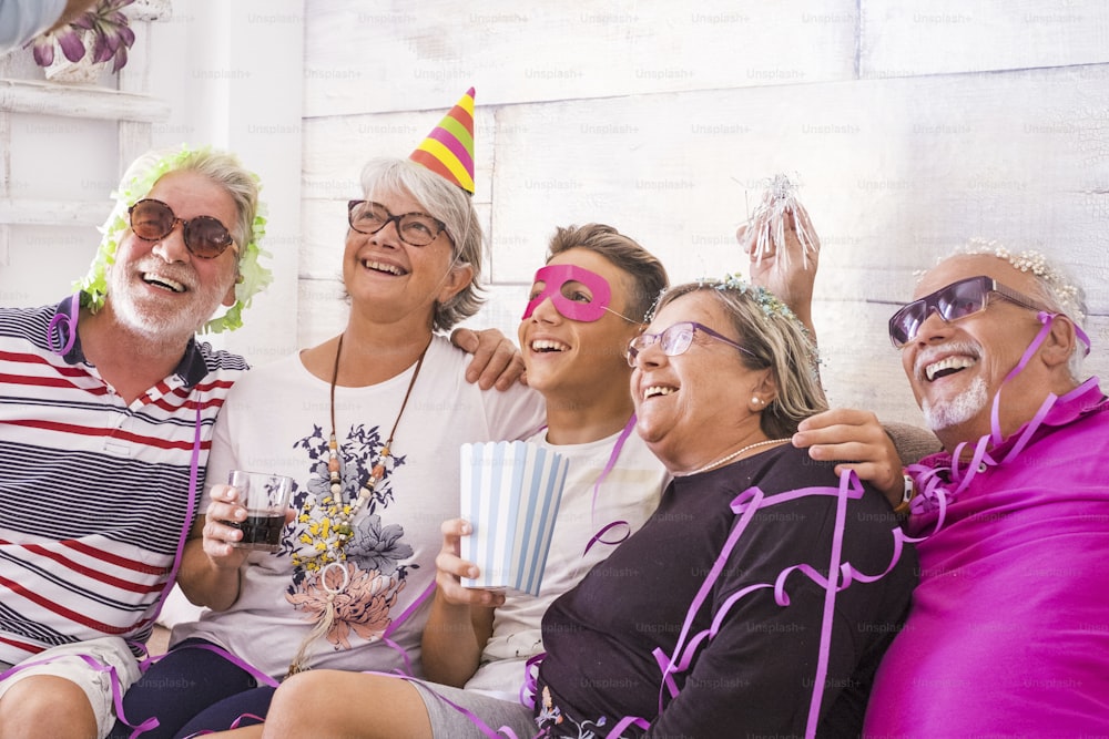 group of cheerful happy caucasian people mixed ages generations from grandfathers to grandson having fun together celebrating a party like birthday. carnival concept at home for family - everybody laughing