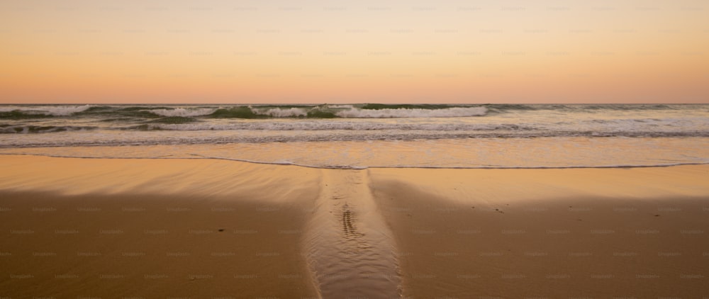 休日の夏休みのための天国のような美しい砂浜。カラフルな背景に夕暮れ時の海側と波。誰もいない