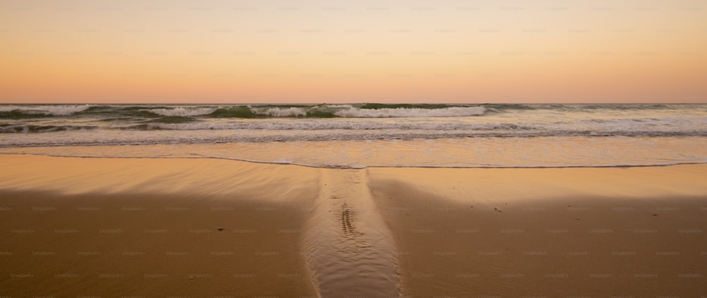 Hermosa playa de arena como el paraíso lugar para vacaciones de verano vacaciones. lado del océano y olas durante una colorida puesta de sol de fondo. nadie allí