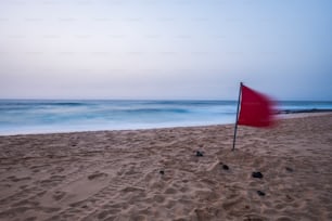 긴 노출 촬영으로 이른 아침 시체가없는 외로운 해변. 바다의 모래와 푸른 물. 푸에르테벤투라 모래 언덕 다음 휴가지를 위한 코랄레호 숙소. 붉은 위험 깃발
