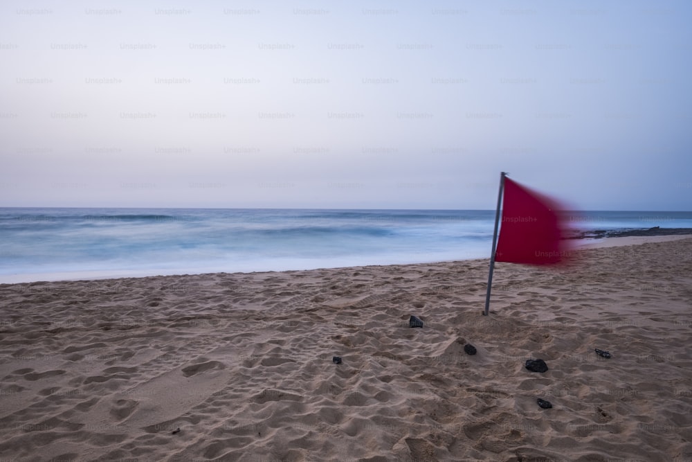 lonely beach with no body there early morning with long exposure shoot. sand and blue water of the ocean. Fuerteventura dunes Corrralejo place for your next vacation destination. red danger flag