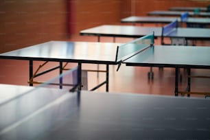 Grande table pour jouer au tennis avec filet bas au centre dans la salle vide