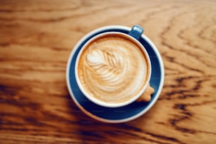 Top view of delicious creamy cup of coffee on desk.