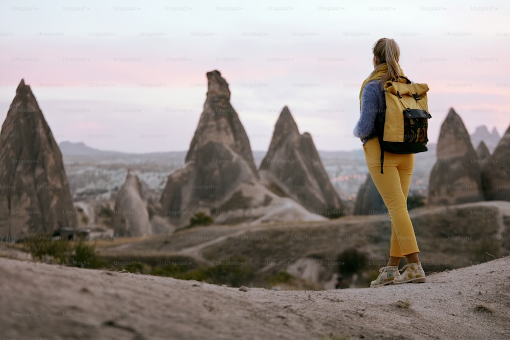 Viajar. Mulher que viaja na natureza com mochila. Menina no Vale das Pedras na Turquia. Alta Resolução