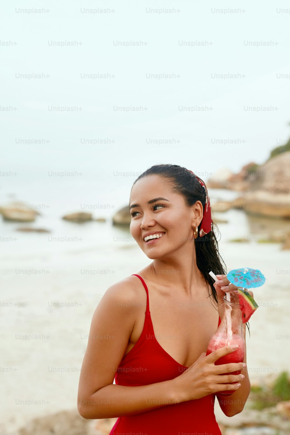 Fiesta en la playa. Hermosa mujer con cóctel exótico en las manos. Chica asiática con bebida de batido de frutas. Alta resolución