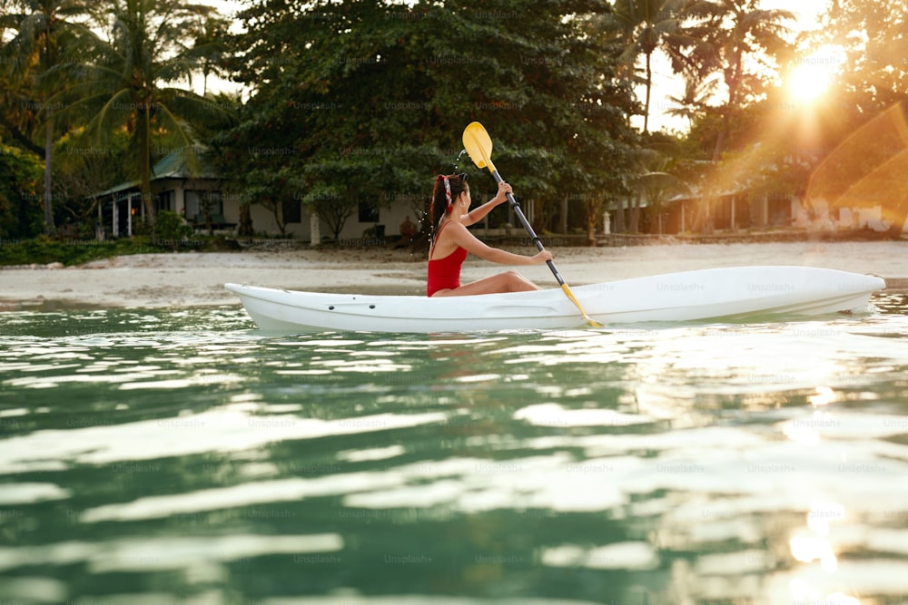 Summer Travel. Woman Kayaking In Sea Water Near Green Island. Girl Having Fun Traveling. High Resolution