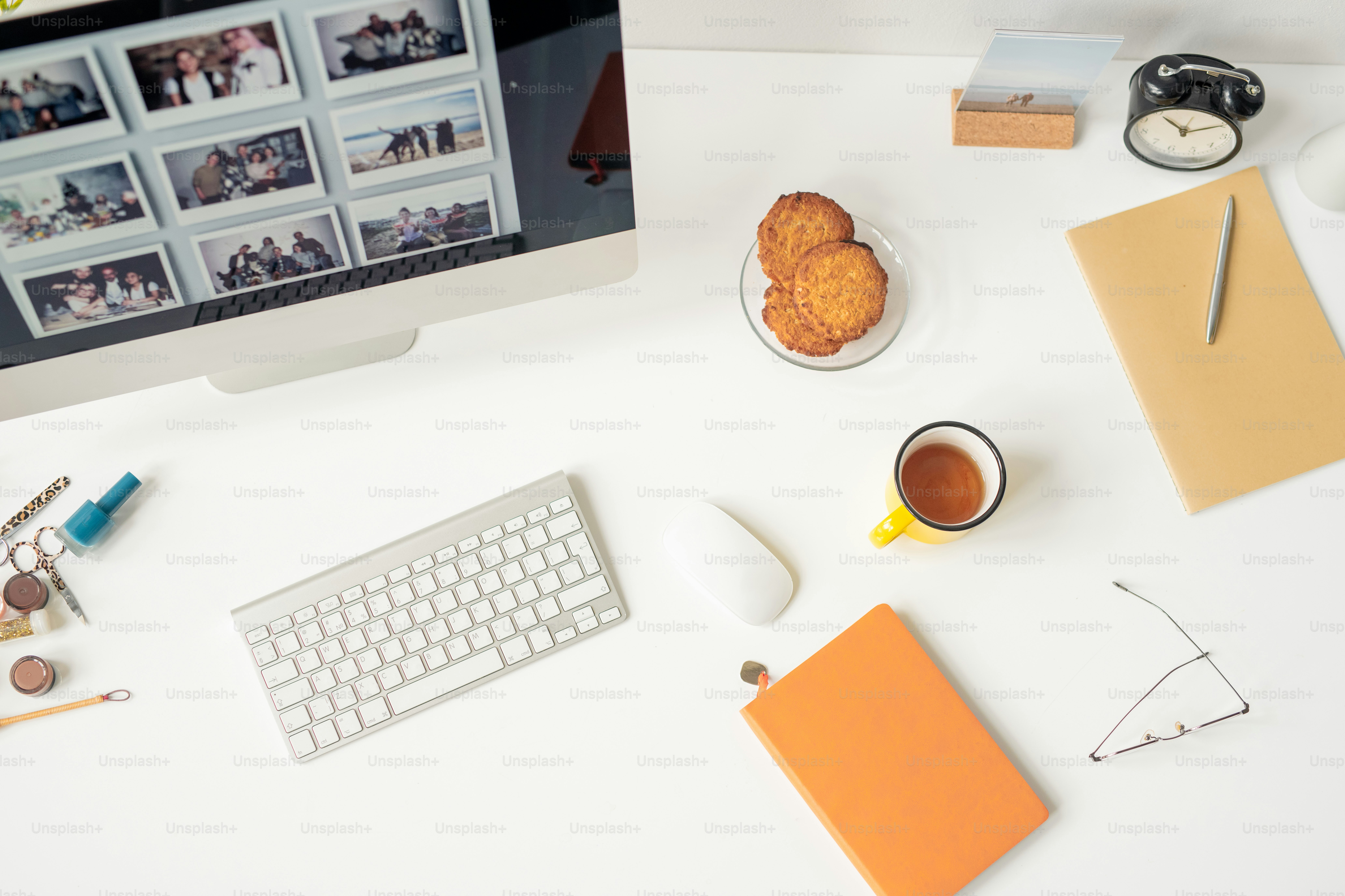 Overview of designer workplace with set of supplies, keypad, mouse, part of computer monitor and snack