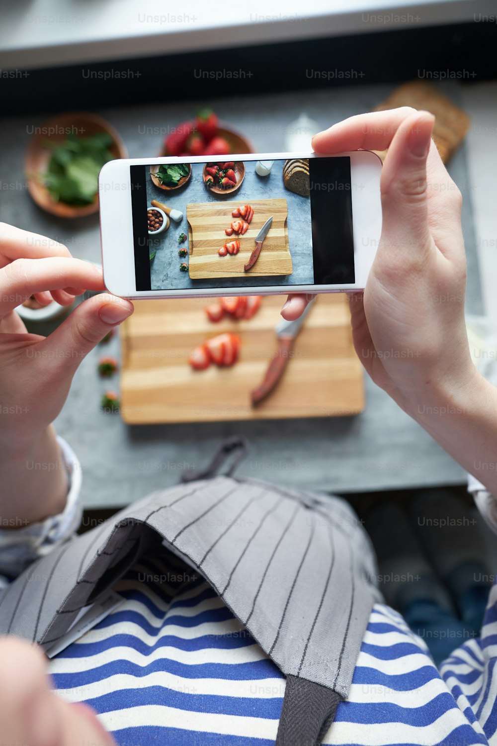 Nahaufnahme der Frau, die mit dem Smartphone gesunde, frisch zubereitete Sandwiches fotografiert, Draufsicht