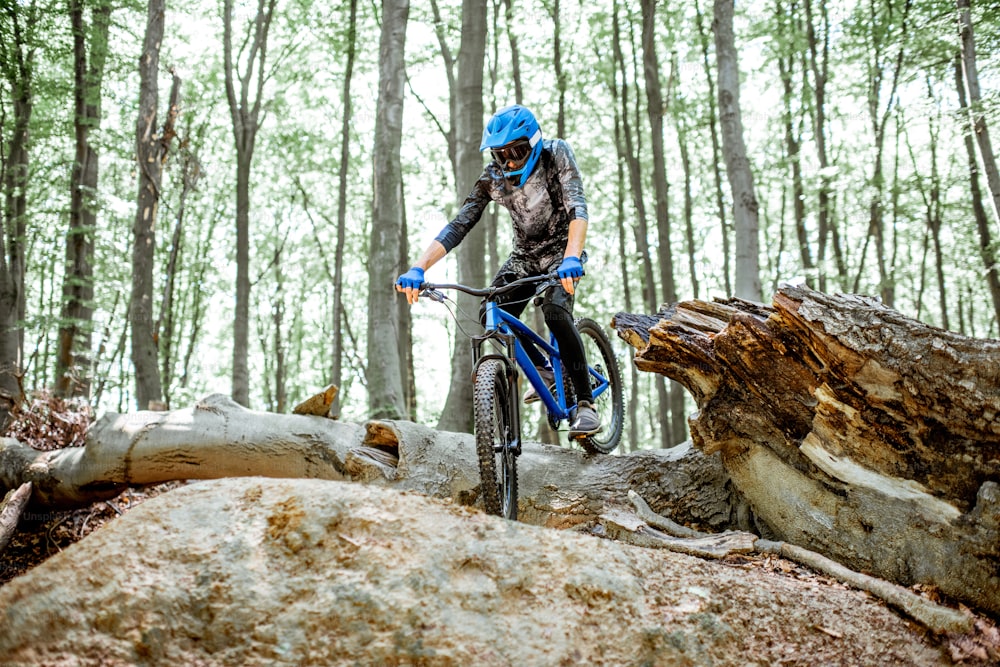 숲속의 오프로드에서 내리막길을 타는 전문 자전거 타는 사람. 익스트림 스포츠와 엔듀로 사이클링의 개념