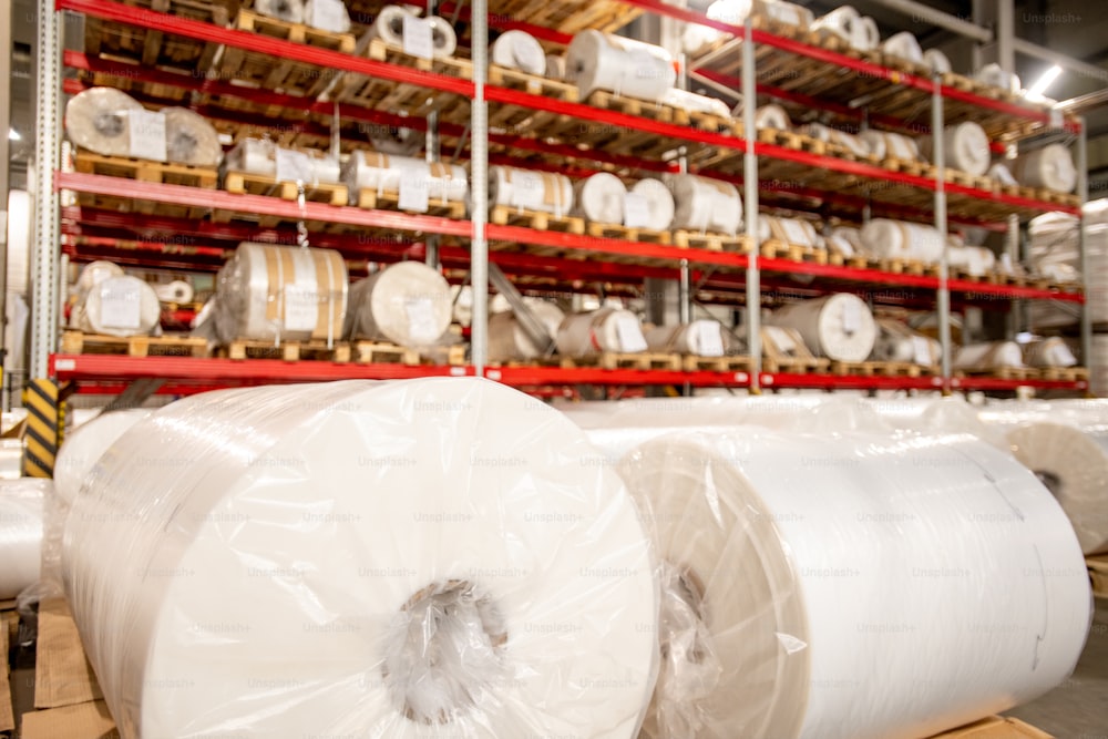 Racks of rolled and packed polyethylene film in storage area of large contemporary chemical production factory