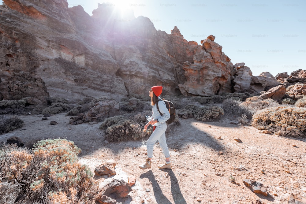 Paisagem de uma bela rocha no vale do deserto com a mulher que viaja no parque natural perto do vulcão Teide na ilha de Tenerife, Spain
