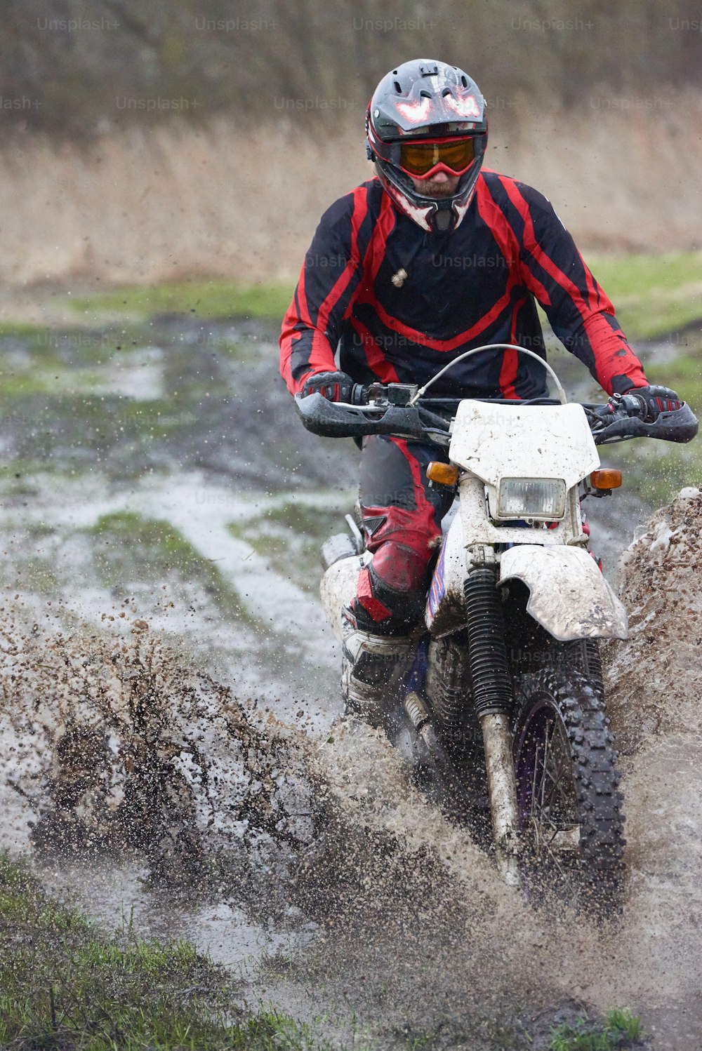 Extreme racing on mud track where young professional biker riding outdoors
