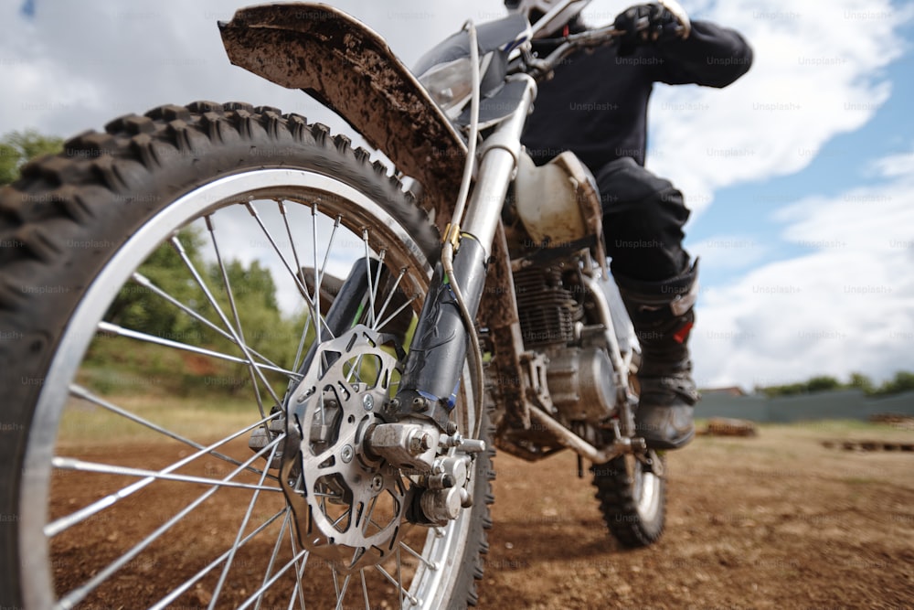 Focus on wheel of brutal motorcycle placed on off-road track, hobby or activity concept