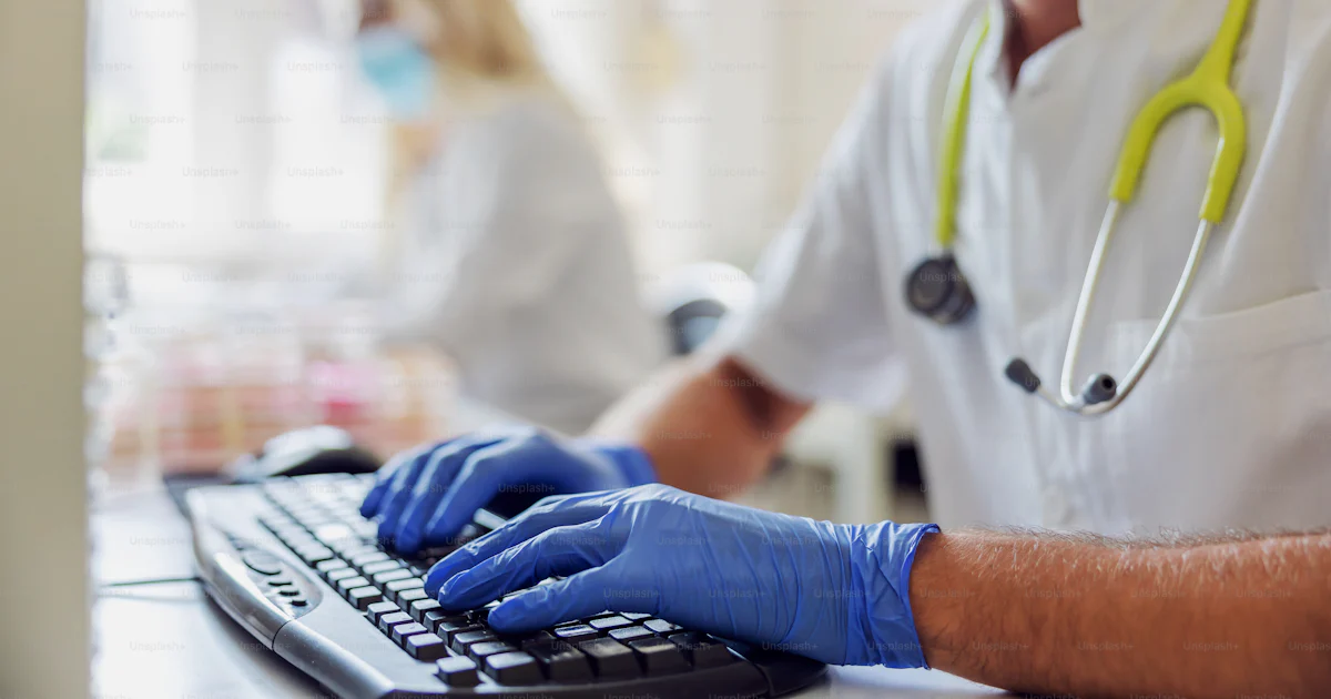 Closeup of male lab assistant sitting in laboratory and entering data ...
