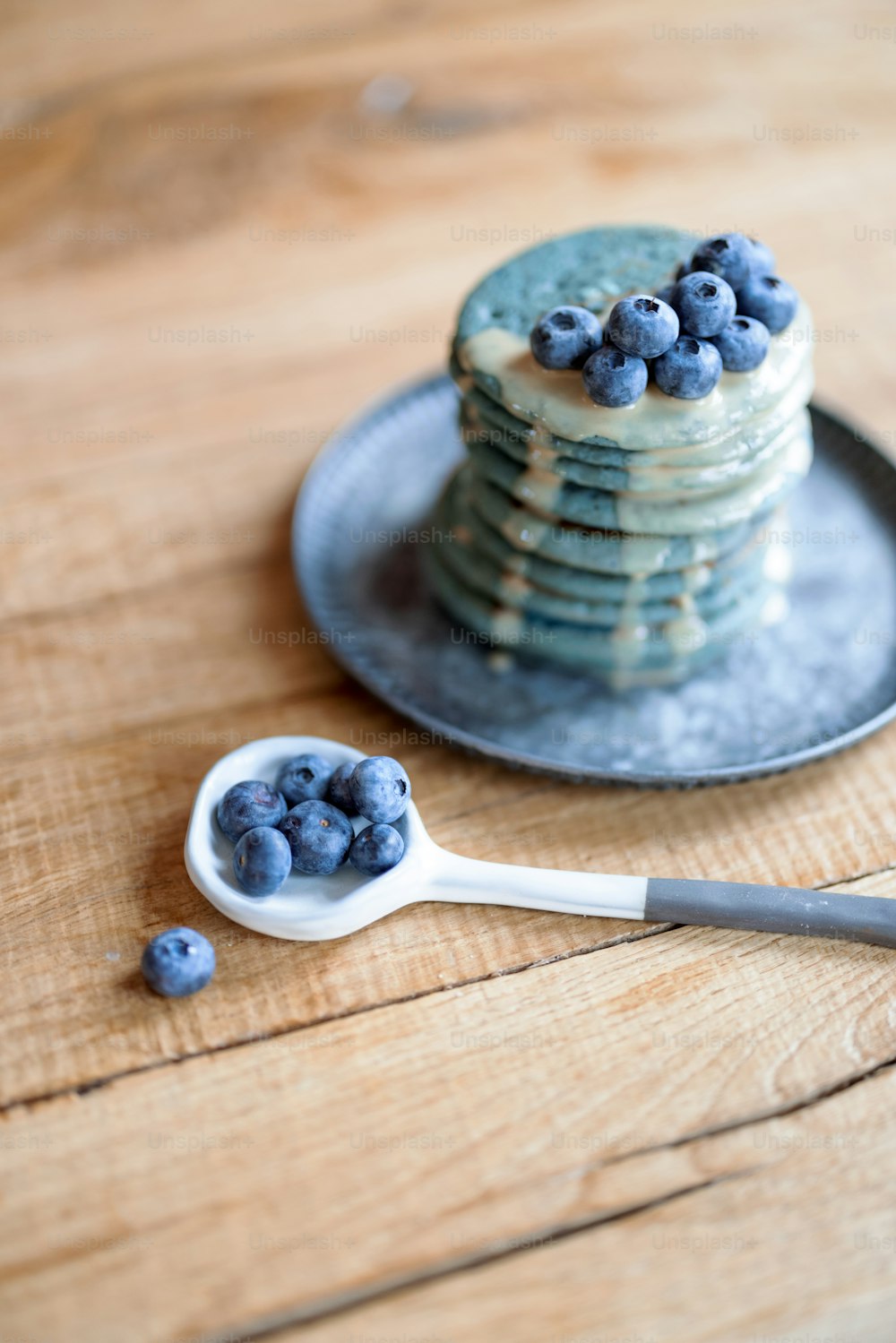 Panqueques americanos azules decorados con azufre de arándanos y caramelo en plato vintage sobre mesa de madera. Comida casera sabrosa. Celebración del Carnaval.