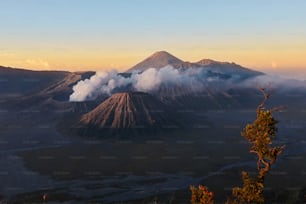 Vulcano attivo in nuvole di fumo con cratere in profondità. Alba dietro il vulcano Mount Gunung Bromo a Giava orientale, Indonesia.