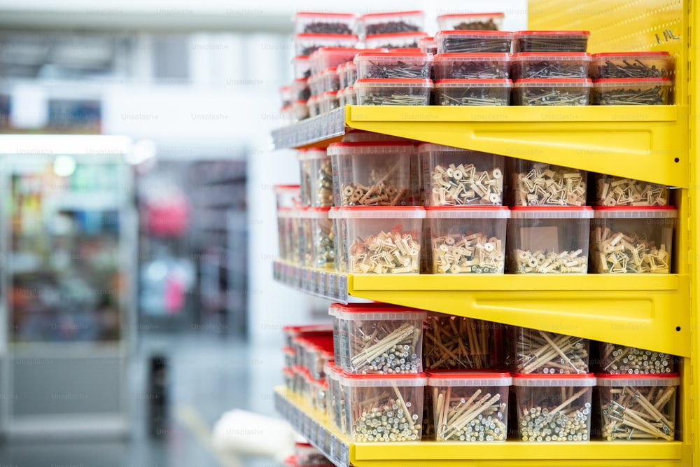 Shelves with nails in stacks of plastic containers in hardware store