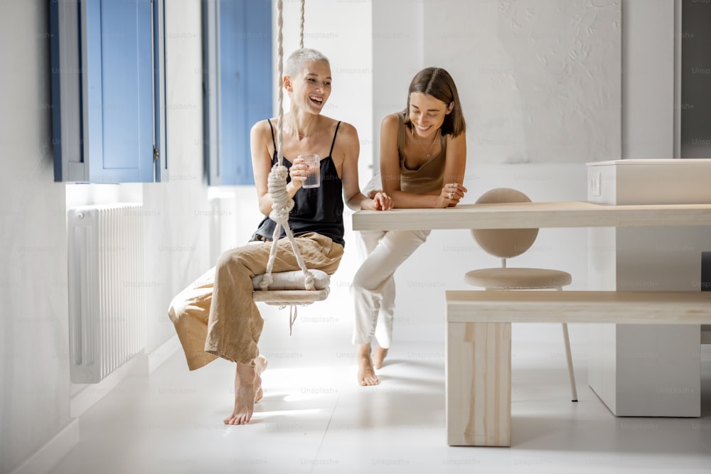 Portrait of a lesbian couple relax together and have fun at modern studio apartment. Concept of homosexual relationships and comfortable living at home
