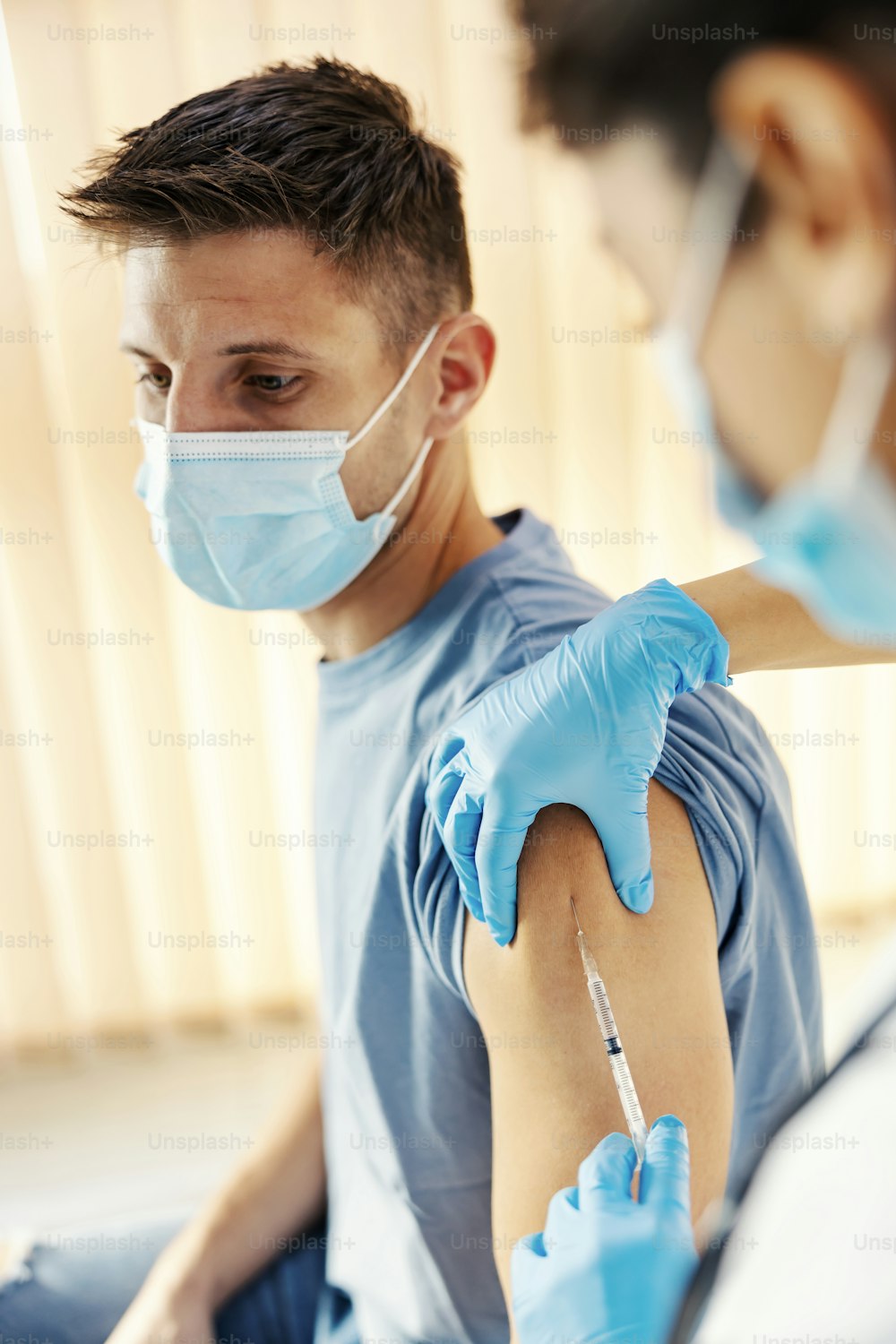 Close up de uma enfermeira injetando a vacina contra a covid 19 no braço de um homem. Medicina, vacinação e imunização.
