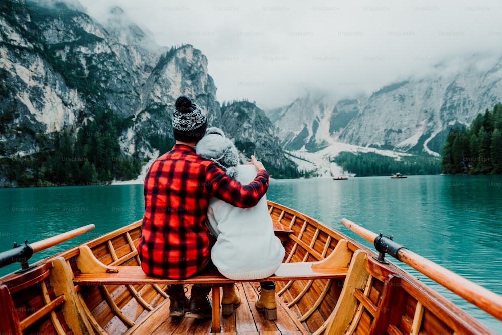 Casal romântico em um barco visitando um lago alpino em Braies Itália. Turista apaixonado passando momentos amorosos juntos nas montanhas de outono. Conceito sobre viagens, casal e wanderust.