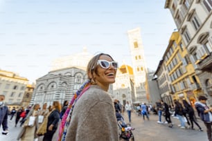 피렌체의 유명한 산타 마리아 델 피오레 성당 근처를 걷고 있는 여자. 이탈리아의 랜드마크를 방문하고 이탈리아를 여행하는 개념. 화려한 숄을 입고 세련된 여자