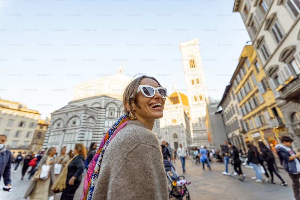 Woman walking near famous Santa Maria del Fiore cathedral in Florence. Concept of visiting italian landmarks and travel Italy. Stylish woman wearing colorful shawl