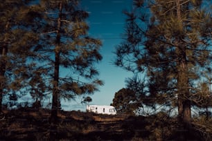 Modern camper van motorhome parked in the nature with sky view. Concept of people and travel vehicle vacation. Adventure vanlife lifestyle and nomadic life. Summer campsite holiday.