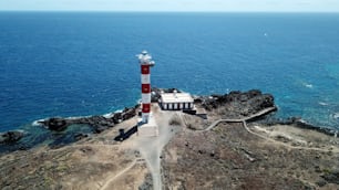 belle vue aérienne du phare ancien et neuf sur la falaise de Tenerife en face de l’océan Atlantique. motard seul regarde la mer