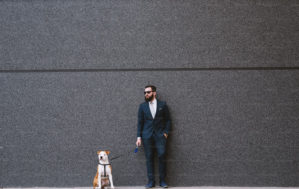 Hombre de negocios paseando perro en la calle. Mejores amigos caminando. Guapo hombre de negocios hipster paseando perro.