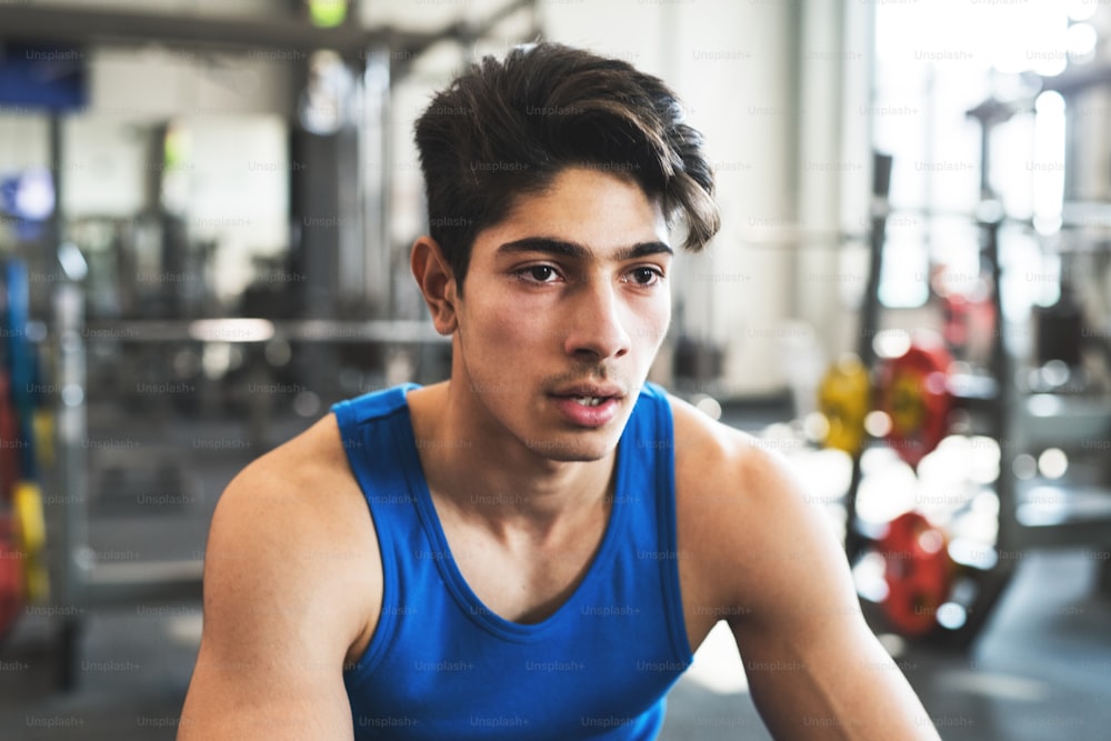 A close up of a young hispanic handsome man in gym gym, resting after an exercise.