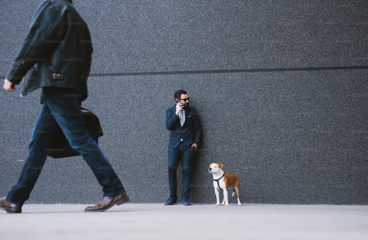 Executivo de terno falando ao celular ao lado de cão em frente ao prédio corporativo PetUnio