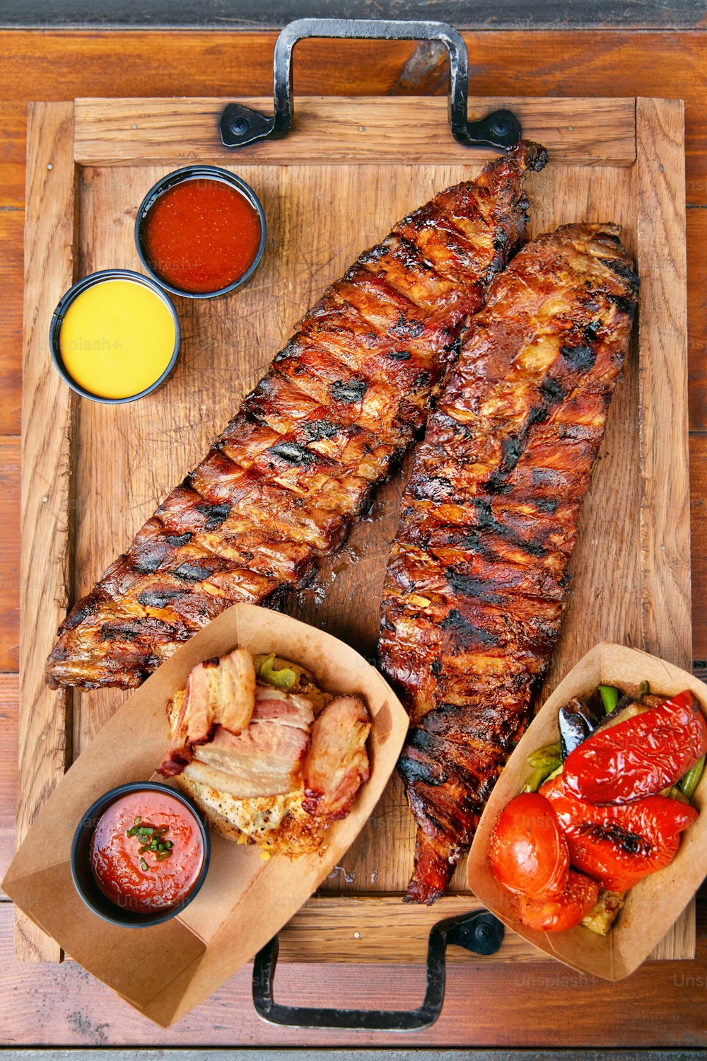 Food Closeup. Grilled Ribs In Barbecue Restaurant. Spareribs With Vegetables And Sauce On Wooden Tray. High Resolution