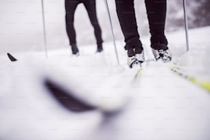 인식 할 수없는 활동적인 커플 크로스 컨트리 스키의 다리. 겨울철.