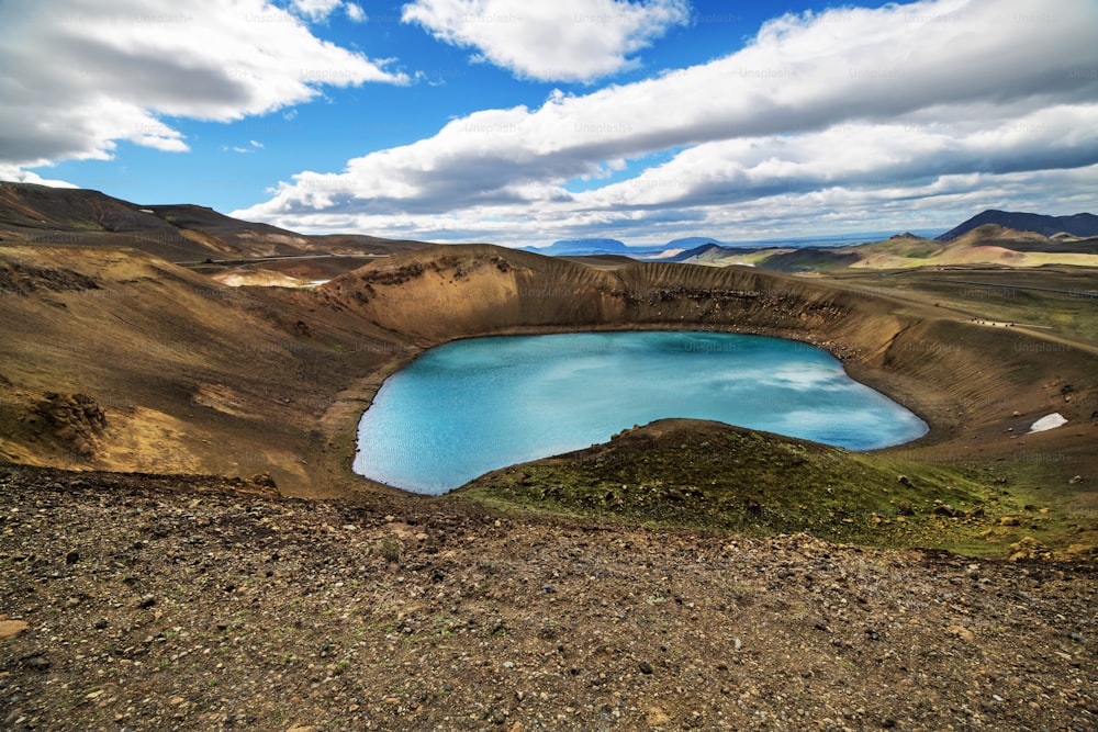 Cráter volcánico con un lago turquesa en su interior, paisaje de Islandia.